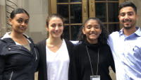 Four undergraduate students standing in front of the Mailman School of Public Health